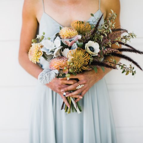 Woman in light blue dress holding eclectic bouquet of various flower types, floral design by Aimee Lomeli Designs, Sonoma and Napa County florist
