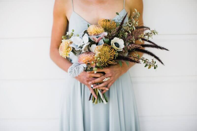 Woman in light blue dress holding eclectic bouquet of various flower types, floral design by Aimee Lomeli Designs, Sonoma and Napa County florist