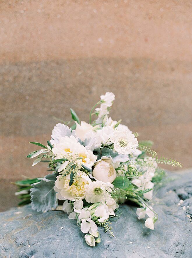 White flower wedding bouquet sitting on top of rock surface at Promontory Winery wedding