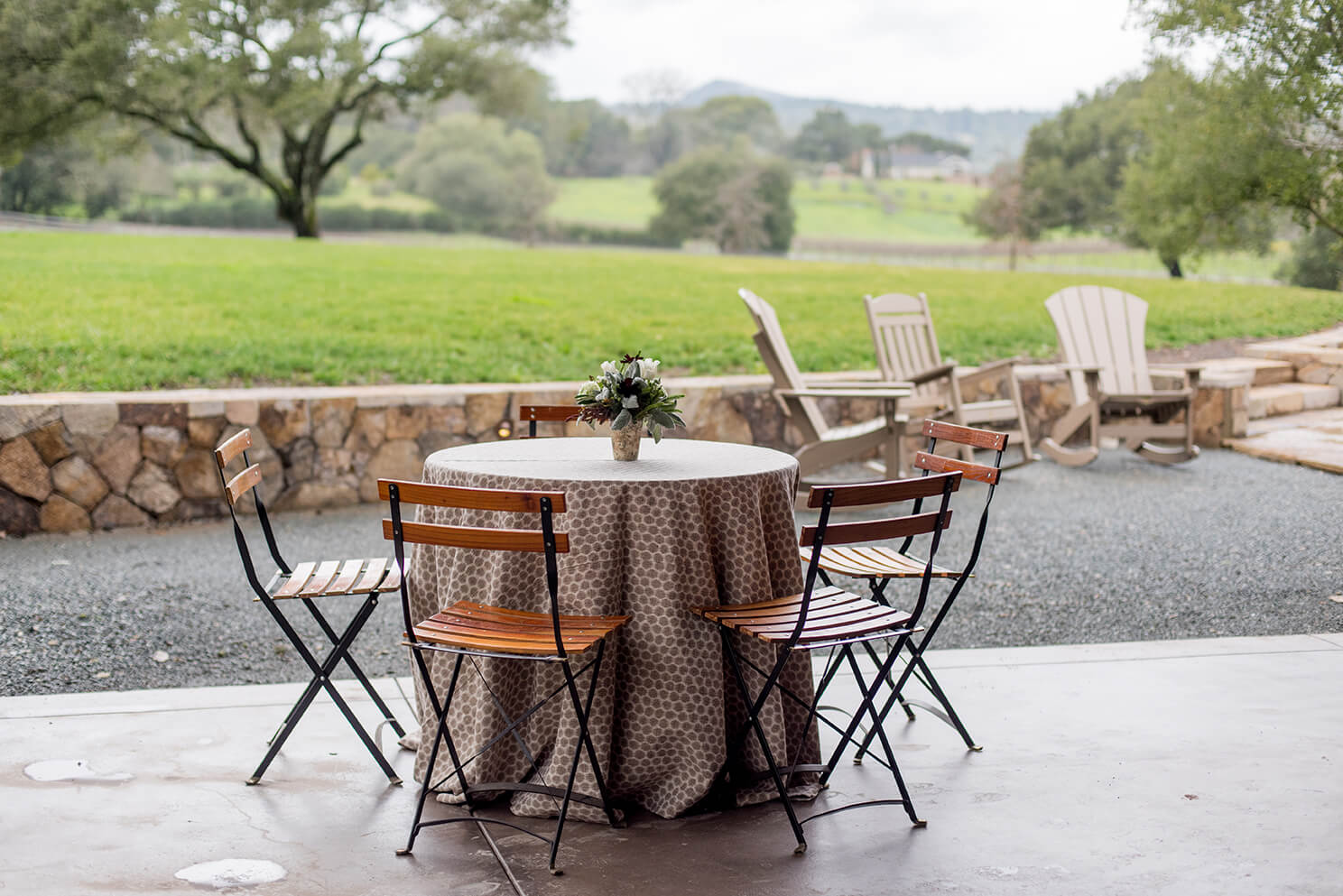 Rustic floral centerpiece on round table in outdoor Sonoma county winery venue