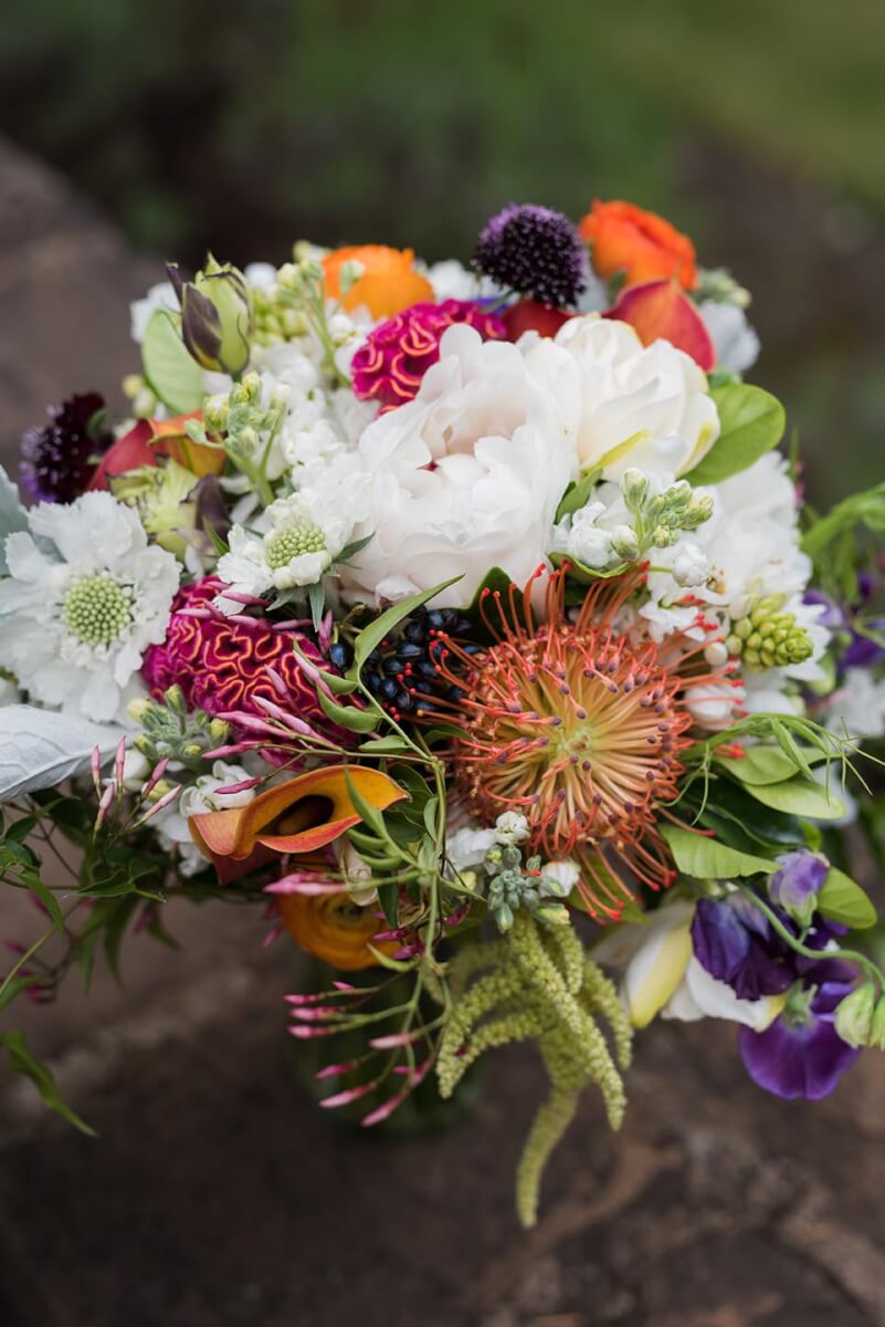 Overhead shot of vibrant floral wedding centerpiece on wood table at Kunde Family Winery wedding