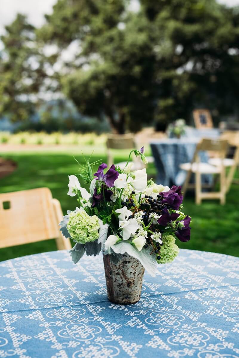 Rustic wedding floral centerpiece on blue tablecloth outdoors at Kunde Family Winery wedding