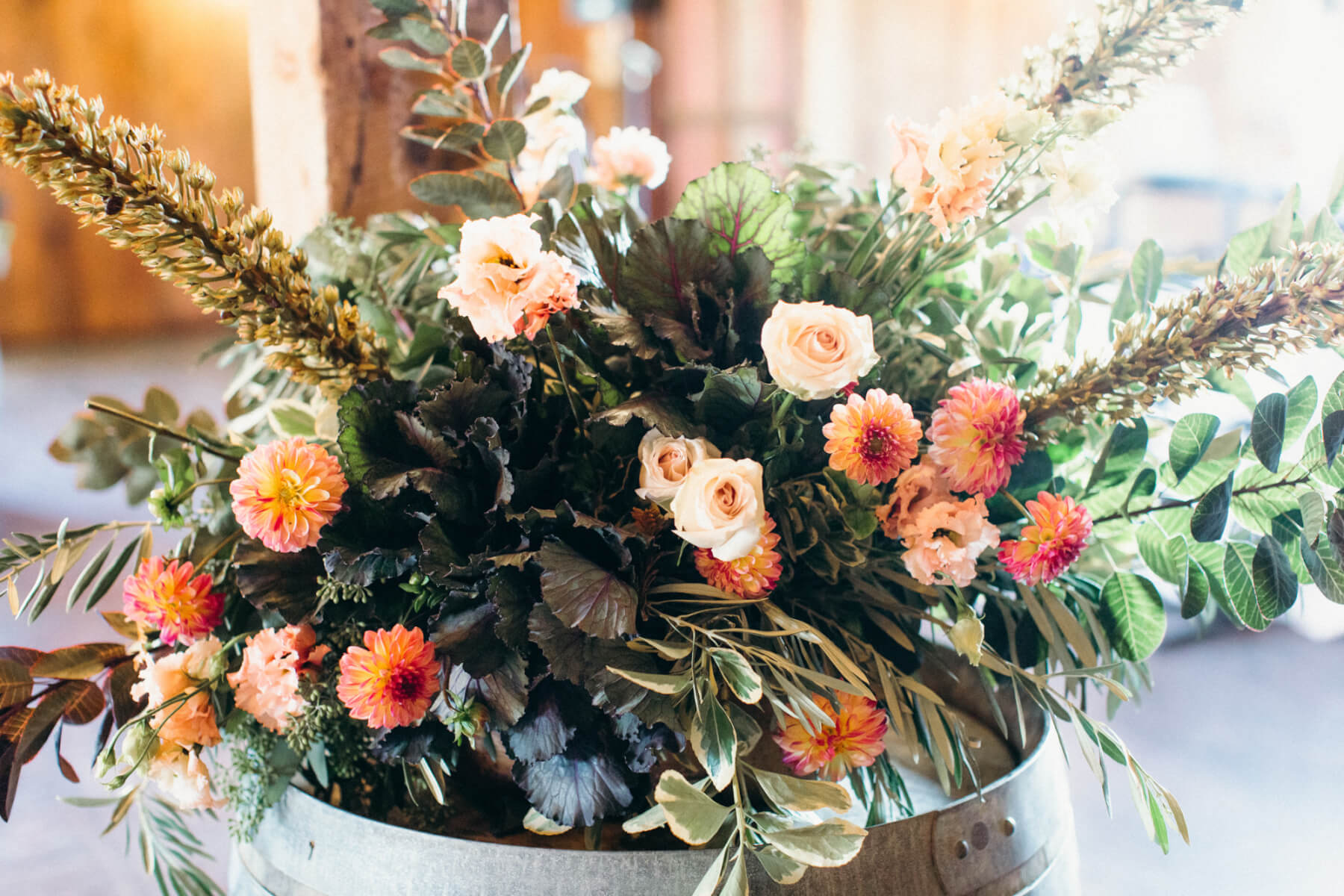 Rustic floral wedding arrangement set atop wine barrel at Stemple Creek Ranch Wedding