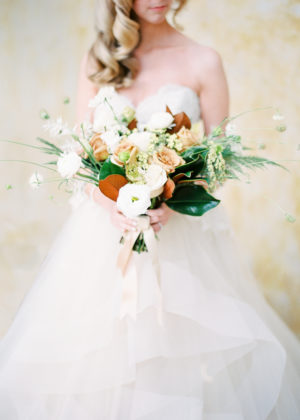 Bride holding white and peach colored wedding bouquet in front of her; floral design by Aimee Lomeli Designs – Sonoma and Napa County florist