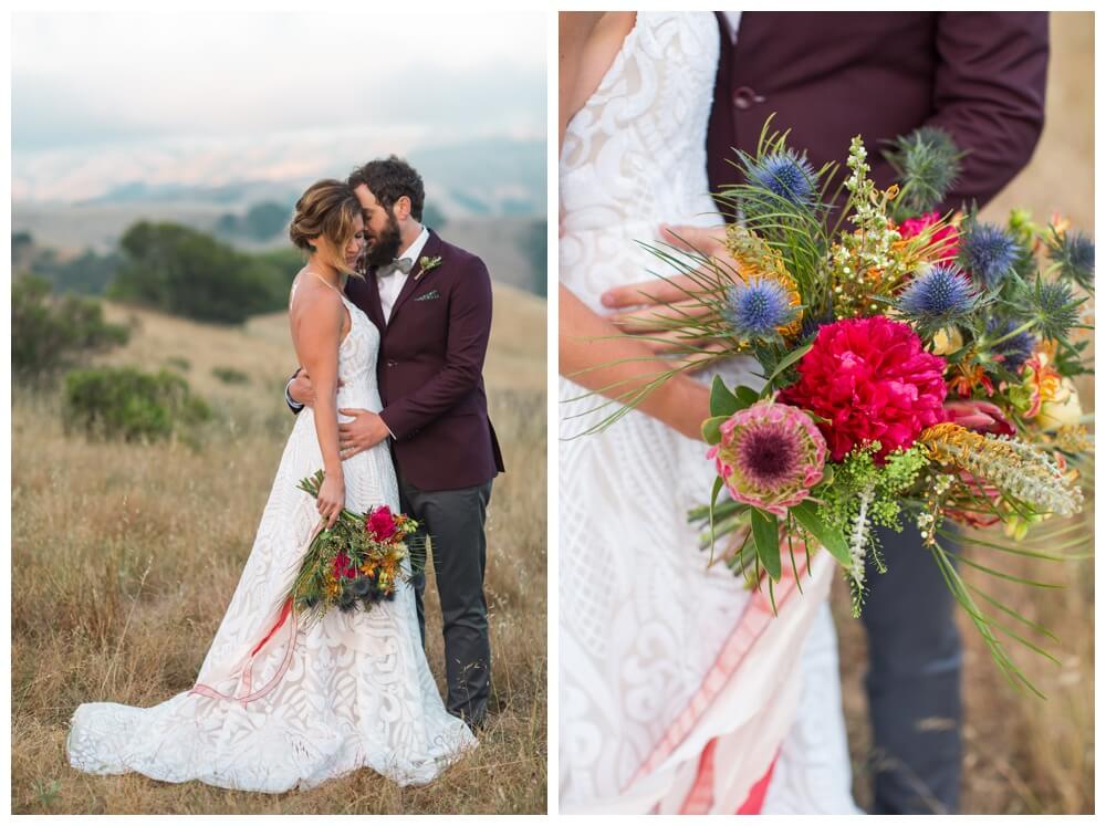 Bride and groom embracing in a field in Sonoma County; the bride is holding a brightly colored bouquet of flowers