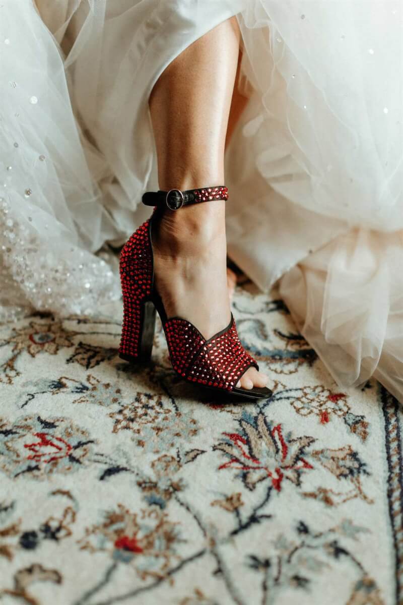 close up of a bride's foot in a red sparkly shoe