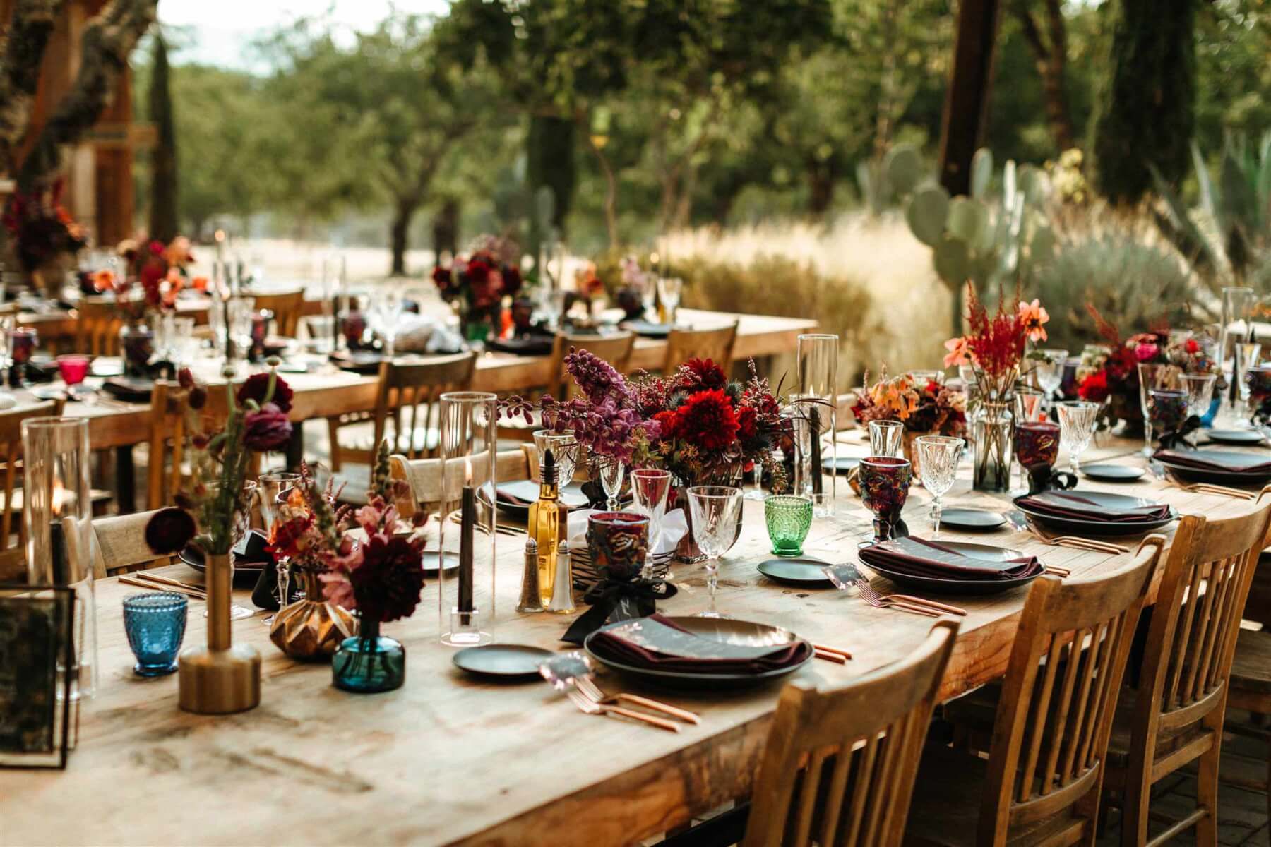 elegant outdoor wedding table place setting with flowers in a moody palette
