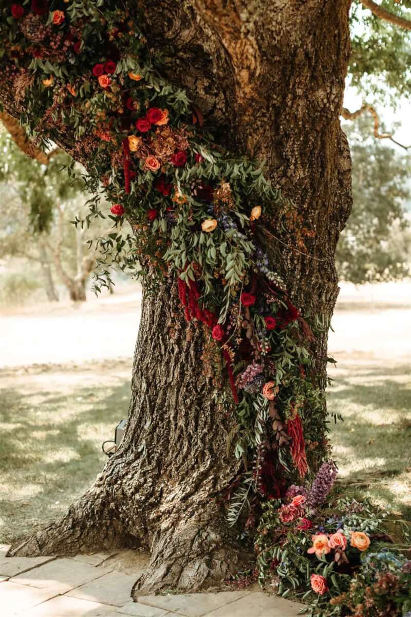 close up of a tree decorated with a swath of flowers for a wedding