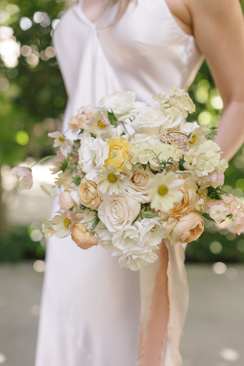 closeup of the bridal bouquet of soft peach and buttercream flowers