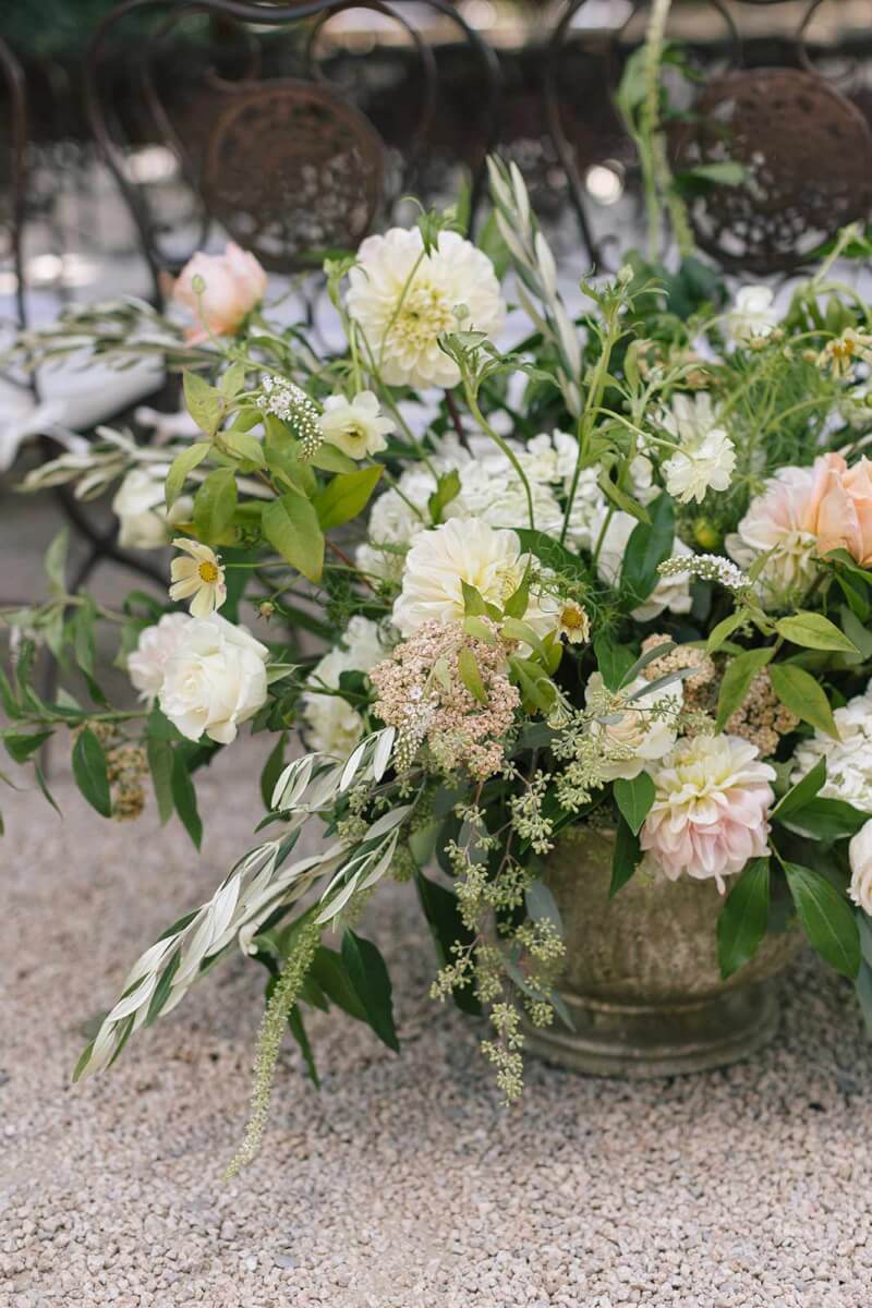 closeup of a vase filled with soft peach and buttercream flowers
