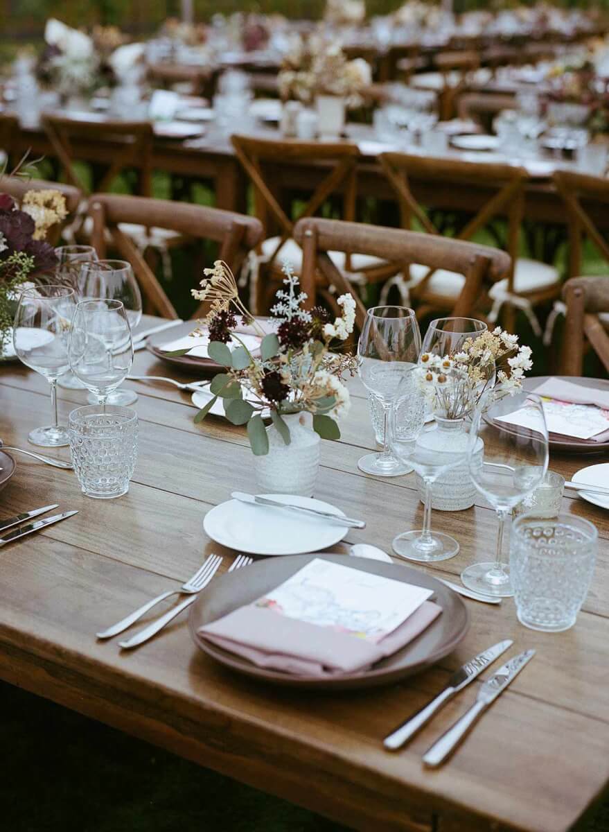 a wedding table place setting with dried flowers in a moody palette