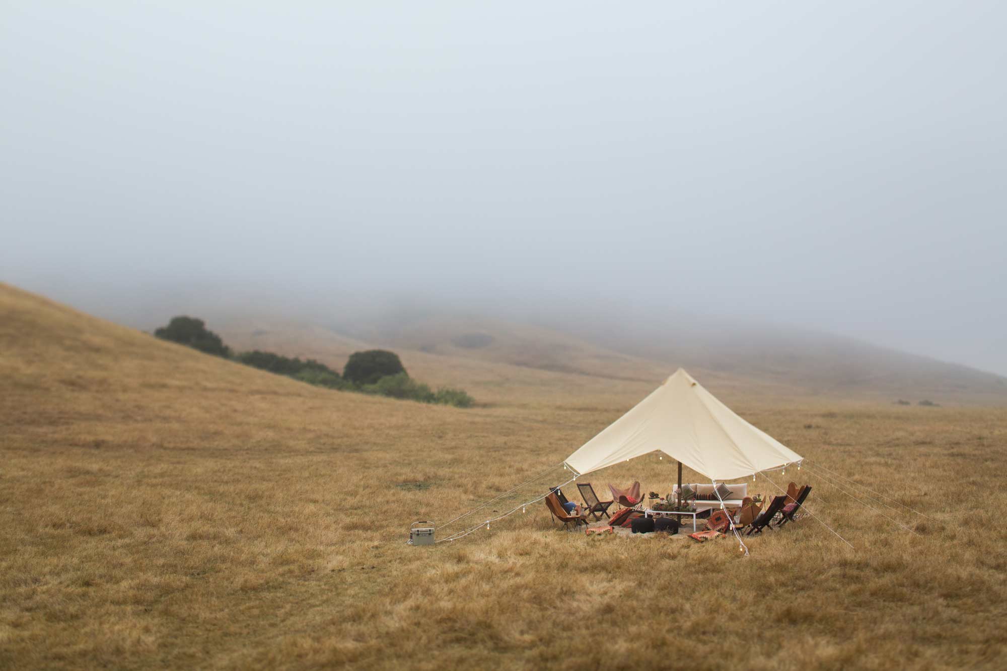 a tent and group of chairs in a field for a wine country ranch event