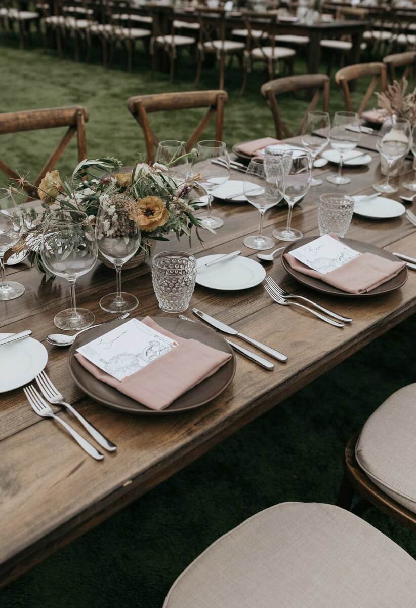 a wedding table set with flowers in earthy moody tones