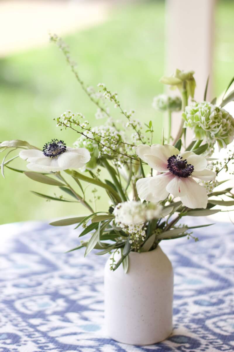 a vase filled with white flowers on top of a table at a winery event