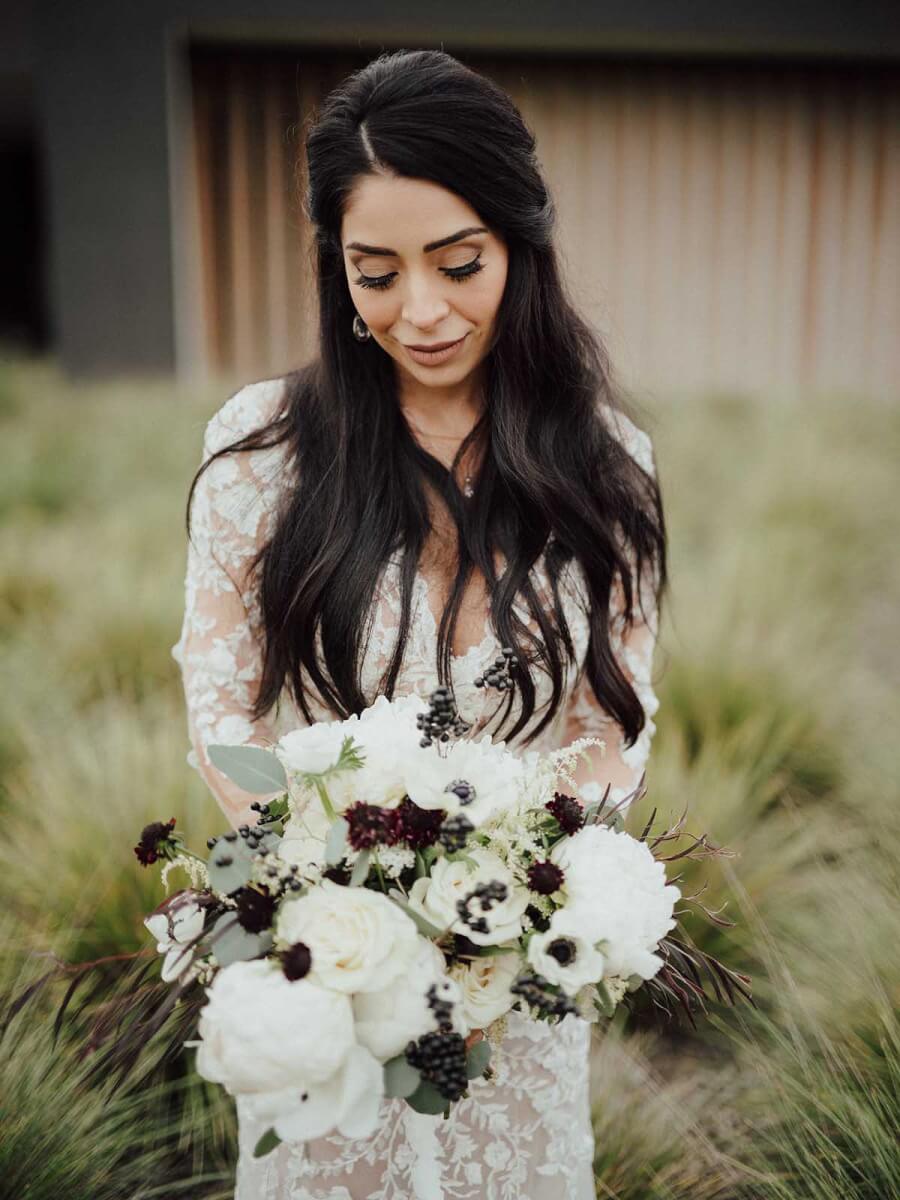 The bride looking down at her elegant black and white bridal bouquet