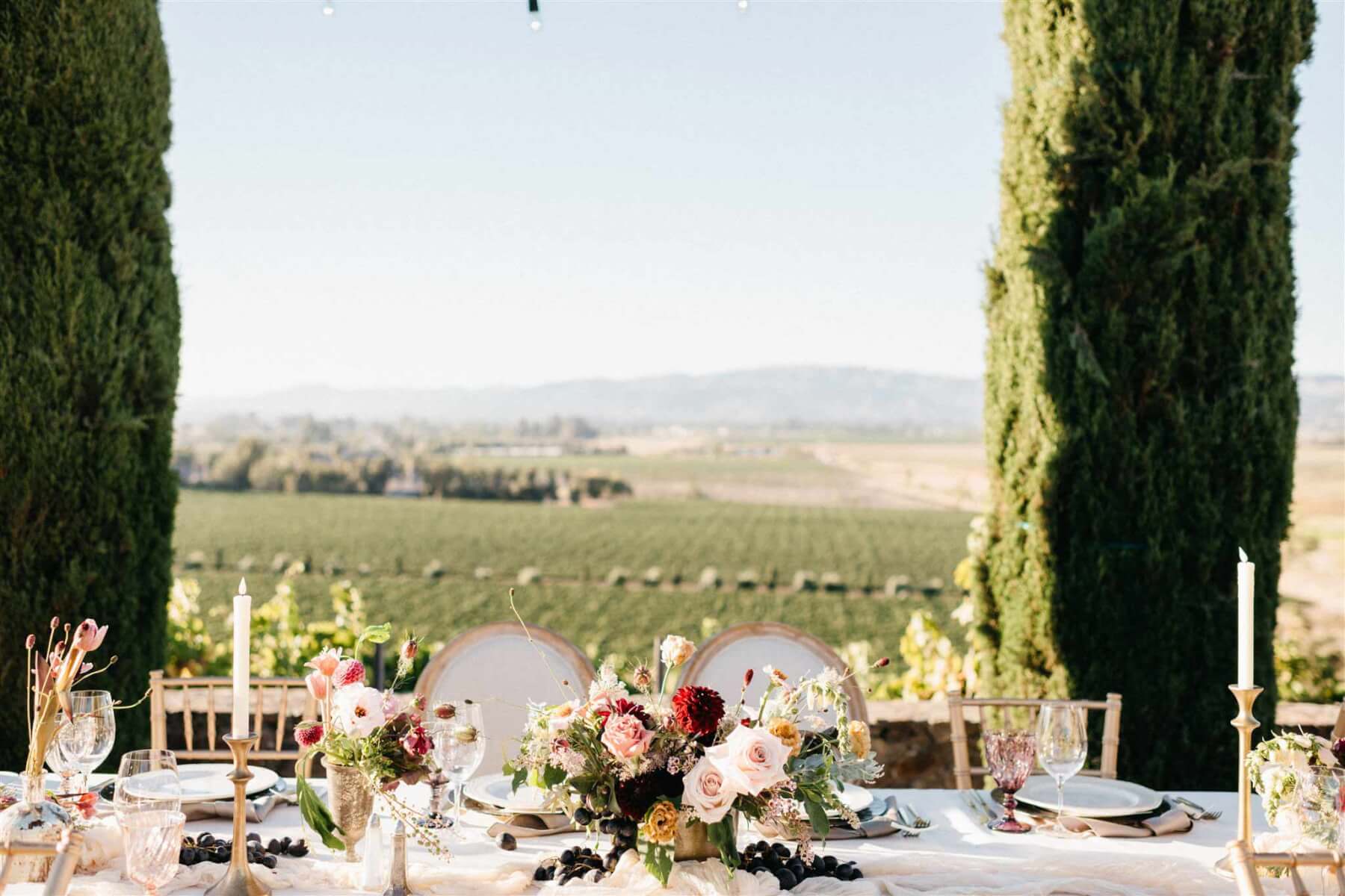 A table set up for the wedding in the vineyard with elegant floral arrangements.